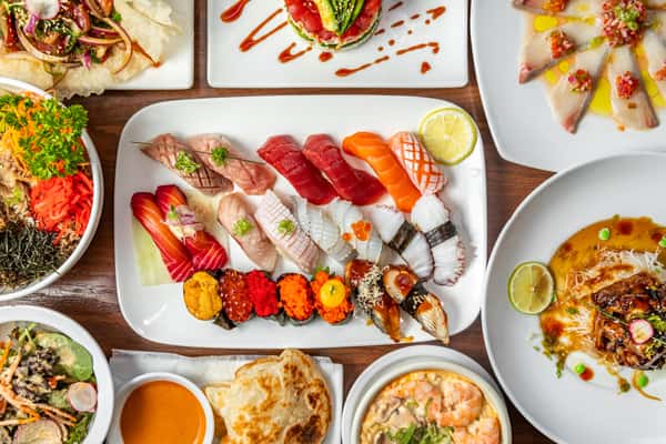 A large plate of sushi with a variety of entrees around it