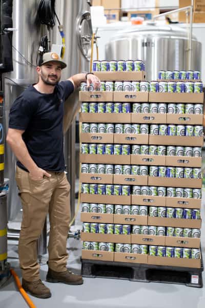 man standing in front of cases of beer