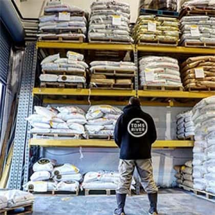 Man standing in front of shelves of grain