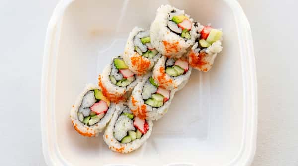 Fresh California sushi rolls filled with avocado, cucumber, and crab on a white plate
