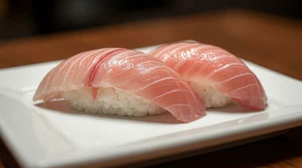 Fresh tuna nigiri sushi served on a white plate with delicate presentation