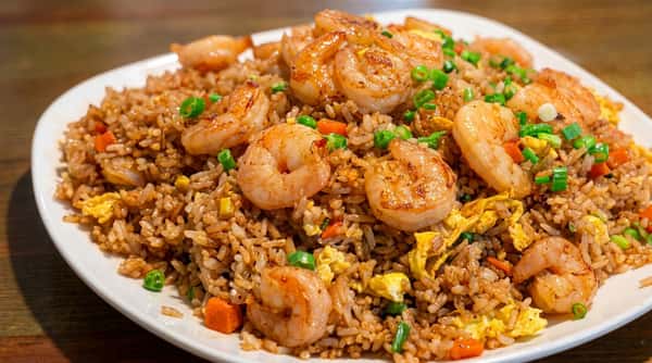 Shrimp fried rice with vegetables, egg, and savory seasonings on a white platter