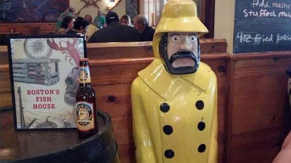 Sailor statue beside a beer bottle