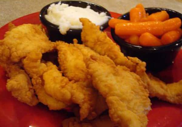 Fried fish with a side of carrots and sauce