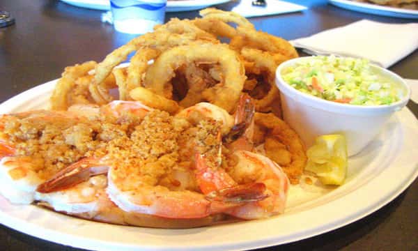 Fried shrimp with a side of onion rings and coleslaw