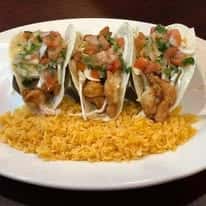Three fish tacos with pico de gallo, cilantro, and lettuce served with a side of yellow rice.