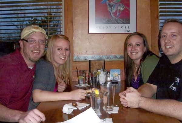 Two couples sitting at a restaurant's table smiling for the photo
