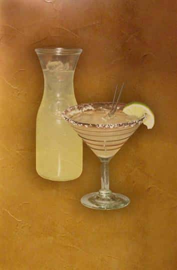A glass and a carafe of margarita