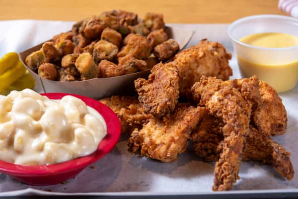 Crispy fried chicken wings served with fried okra, creamy macaroni salad, pickles, and dipping sauce.