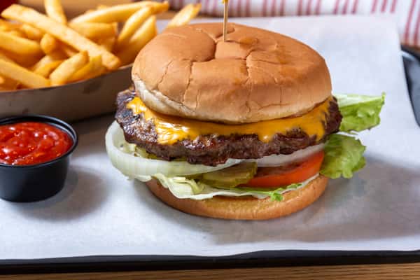 Classic cheeseburger with melted cheddar, lettuce, tomato, and onion served with French fries and ketchup.