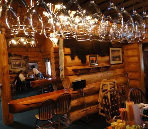 login cabin-style interior with wine glasses hanging from a ceiling fixture