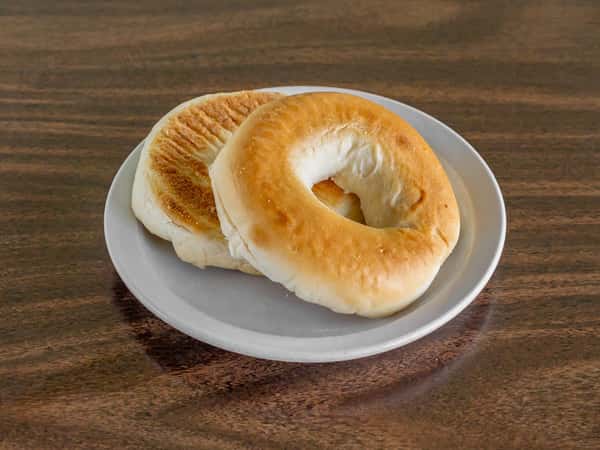 Freshly baked golden bagel halves served on a white plate at Miller's Cafe.