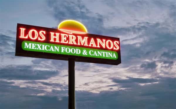 Outside lit up sign of Los Hermanos at night
