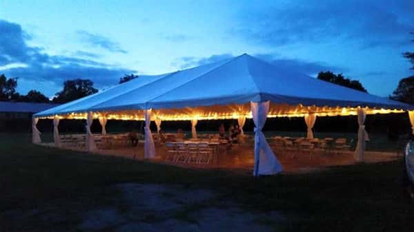 a tent outdoors with christmas lights illuminating it