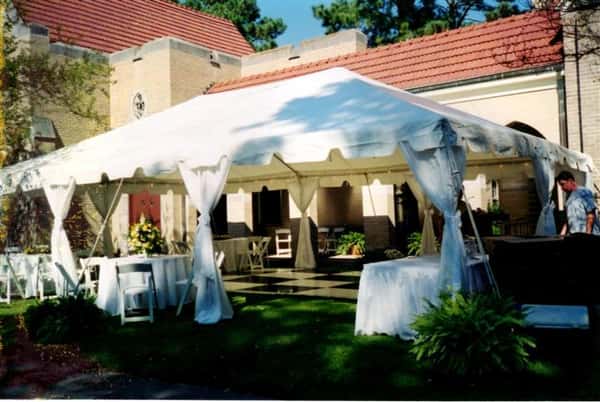 a big tent outside of a rustic house
