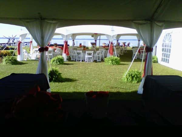 big tent outdoors with circular table and balloons