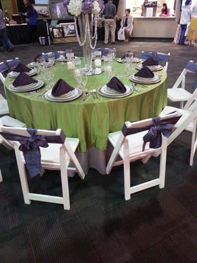 table with tablecloth and napkins and 10 place settings and chairs