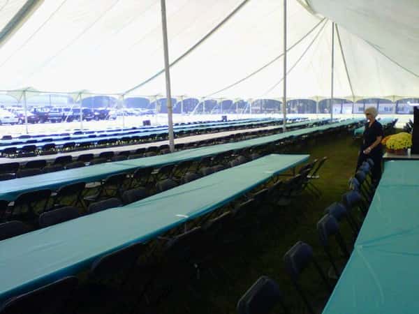 rows of tables and chairs under a huge tent