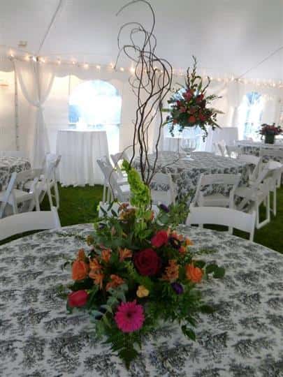 the view inside of a tent with lace tableclothes and floral centerpieces