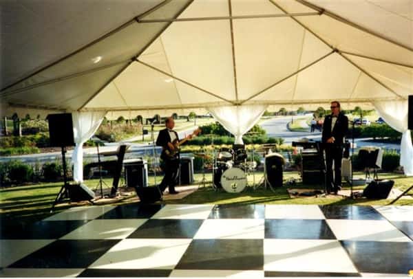 big tent with a band under it with a checkered dance floor