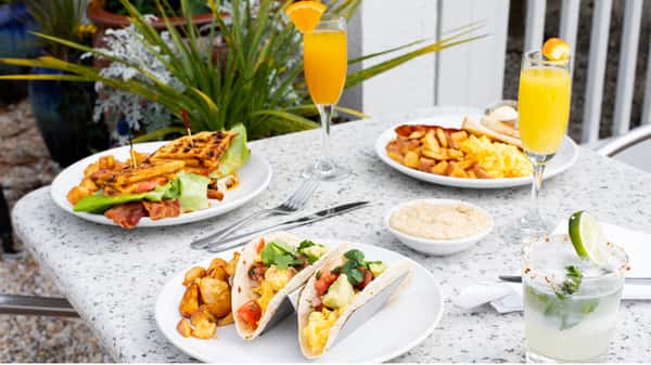 Brunch Dishes of Breakfast Tacos Waffles and Eggs at Bluewater