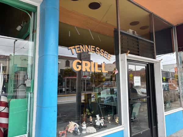 Tennessee Grill storefront with a Tennessee Grill sign in gold lettering on a blue background.