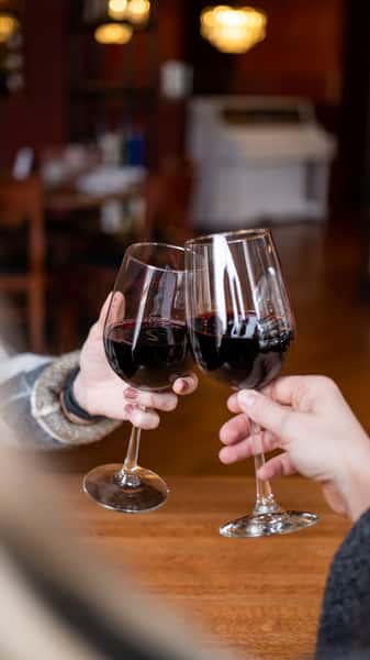 Two wine glasses clinking together