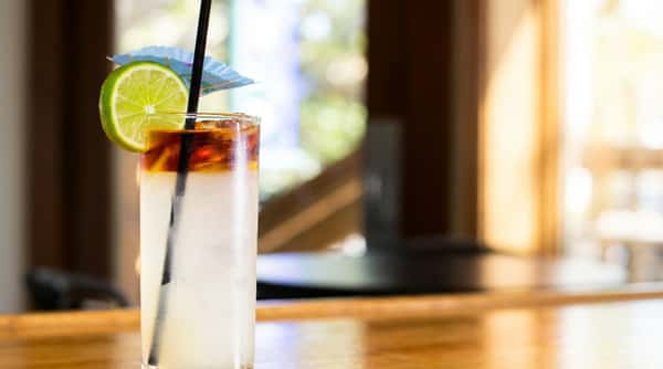 A handcrafted cocktail garnished with citrus and olives, carefully presented for a balanced and flavorful sip.