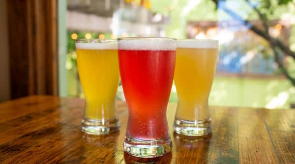 A trio of craft beers showcasing a range of styles and colors, poured fresh and ready to enjoy.