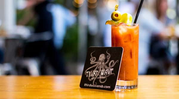 Signature cocktail served with a branded Third Wave coaster, highlighting our café and wine bar identity.