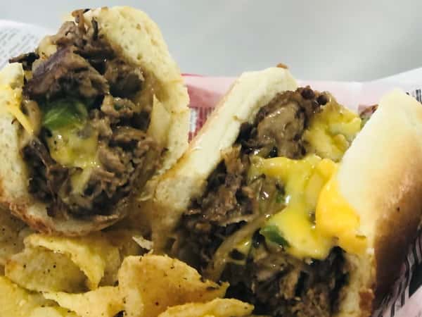 philly cheesesteak with a side of potato chips