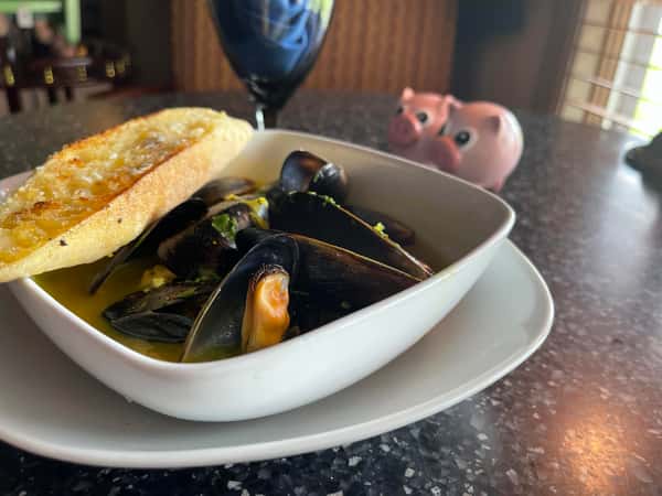 Black mussels in a turmeric white wine broth with a toasted garlic baguette.