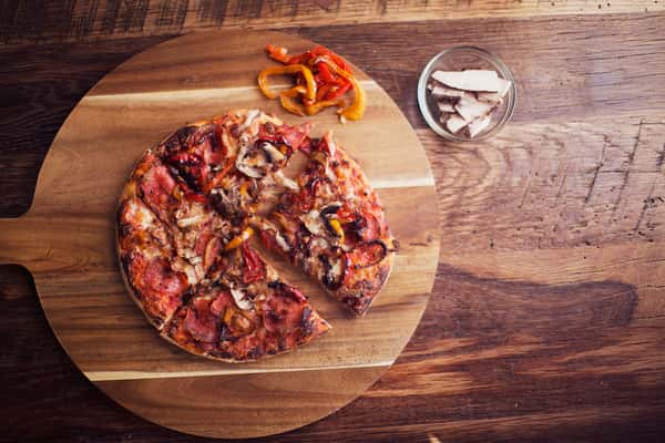Pepperoni pizza on a wood slab