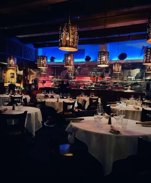 main ding room set for dinner lighted in blue and red lighting white tablecloths on tables