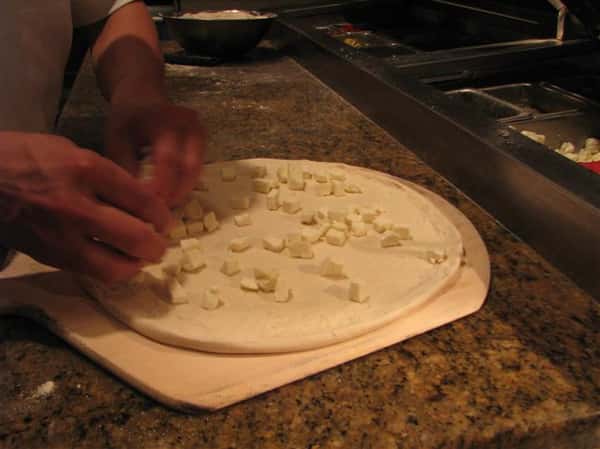 two hands making a pizza