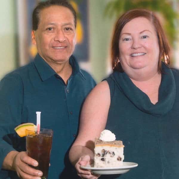 Man and woman holding a drink and coffeecake