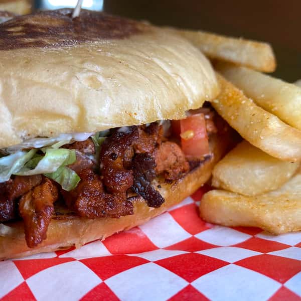 Torta with seasoned pork, lettuce, and tomato served with thick-cut fries