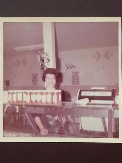 a black and white photo of a woman working the restaurant