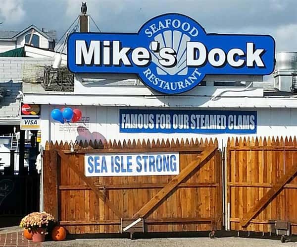 the outside view of mike's dock seafood resturant with a "Famous for our steamed clams" and "Sea isle strong" sign