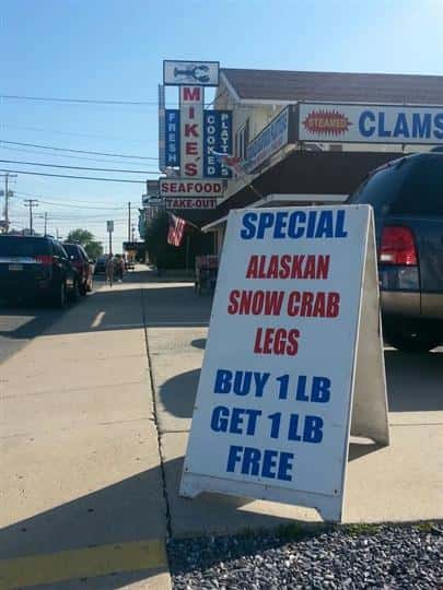 a specials sign that says "special alaskan snow crab legs buy 1 lb get 1 lb free"