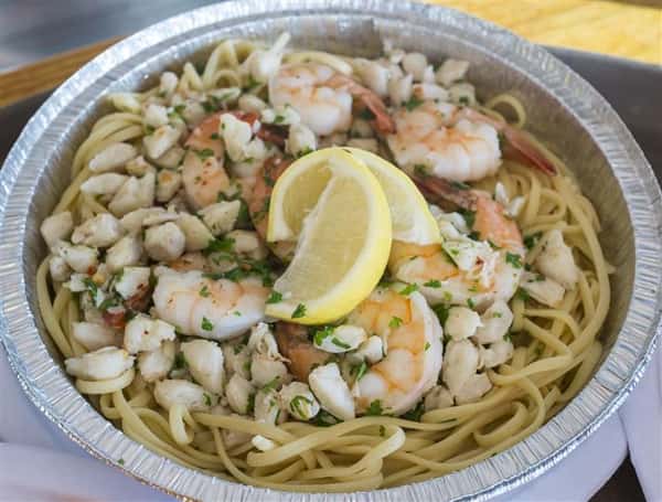 shrimp linguini with scallops and lemon wedges