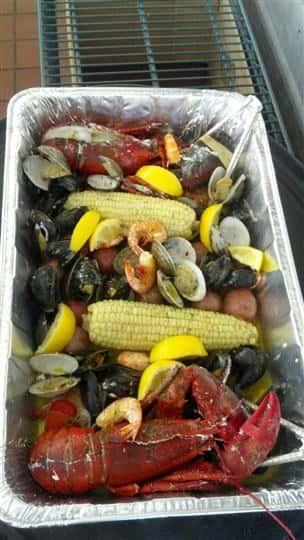 a seafood boil of corn on the cob, lobster, clams, mussels, and shrimp