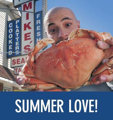 a man holding a crab in front of mike's seafood with the text "summer love!"