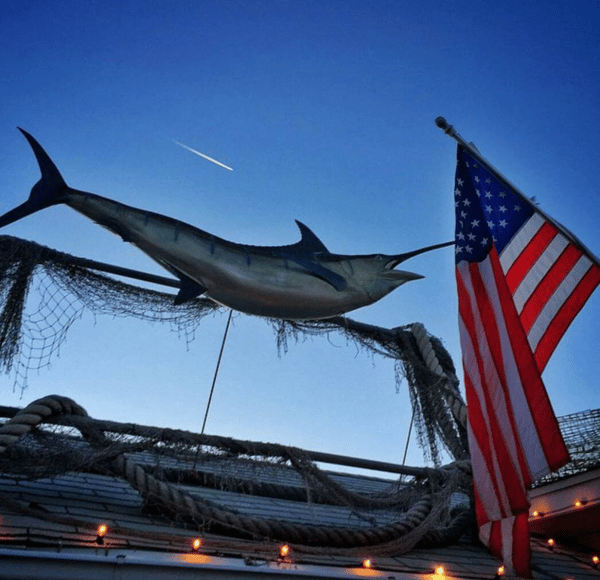 a phptp pf the swordfish statue on the roof of he restaurant