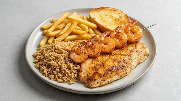 Grilled shrimp skewer served with rice, bread, and french fries