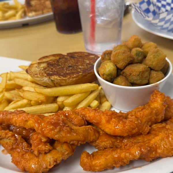 Plate of fried chicken tenders with french fries, fried okra, and a biscuit