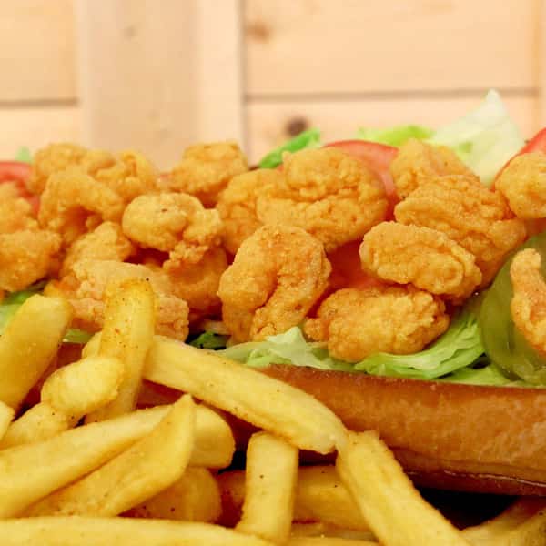 Fried shrimp po'boy sandwich with lettuce, served with french fries