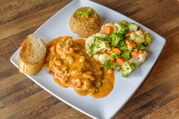 Shrimp in cream sauce with rice, mixed vegetables, and garlic bread