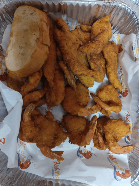 Basket of fried fish and chicken tenders with a slice of bread