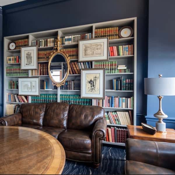 sitting area with large bookcase and leather couch